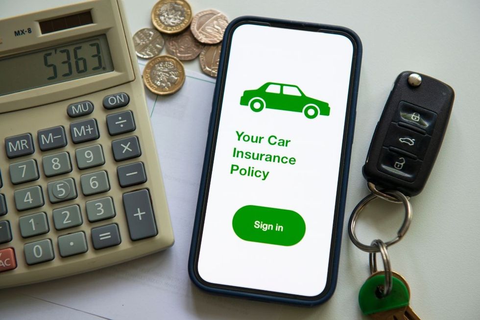 A car insurance policy surrounded by coins, car keys and a calculator