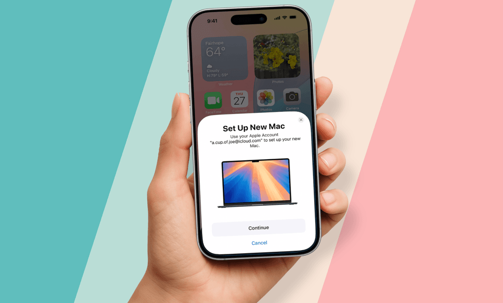 a hand holding an iphone with the Set Up New Mac prompt showing on-screen