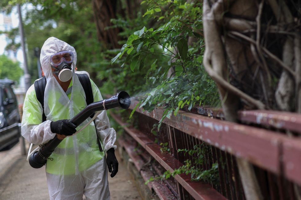 A Hong Kong official sprays down a public park amid the chikungunya outbreak