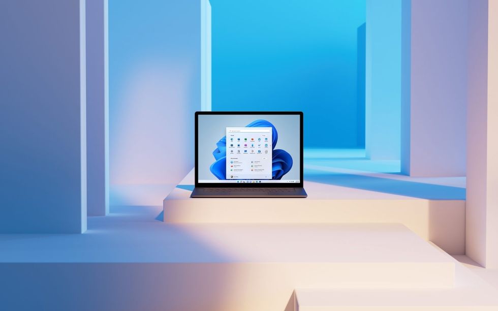 a laptop running windows 11 is pictured on a series of colourful ledges