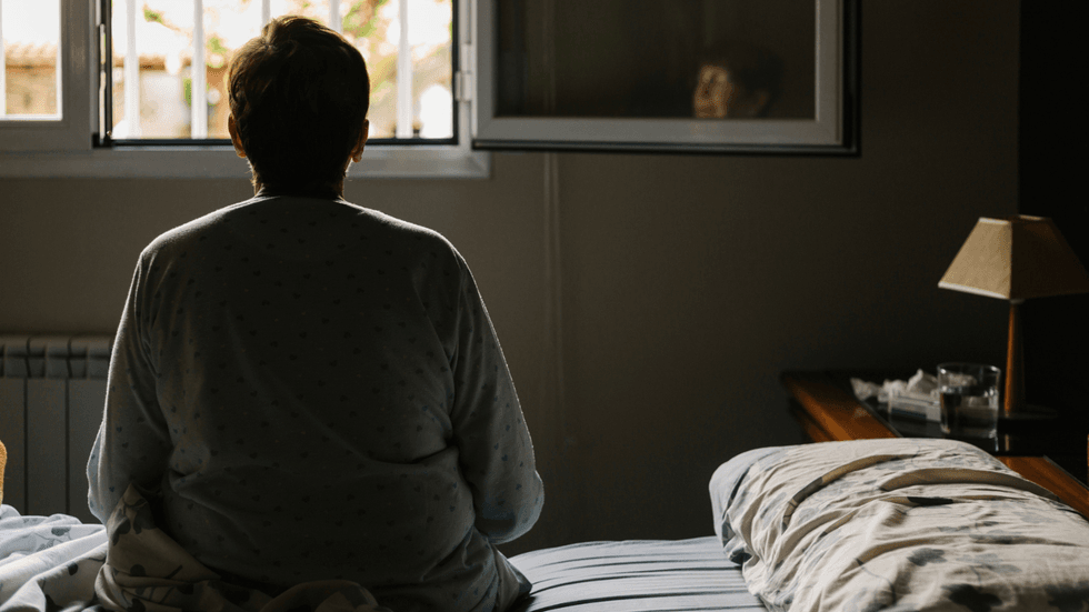 A woman sat on her bed