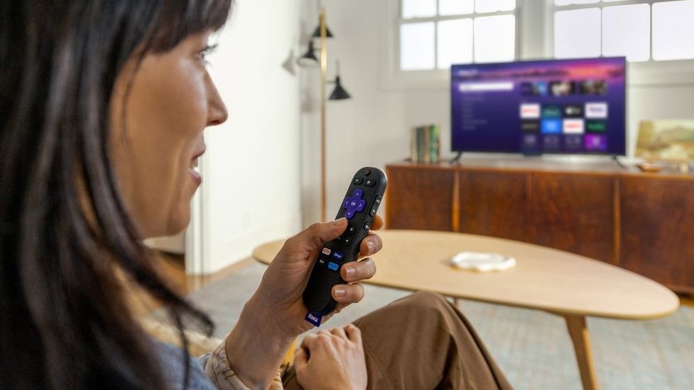 a woman speaks into the voice control remote of the new Roku Streaming Stick
