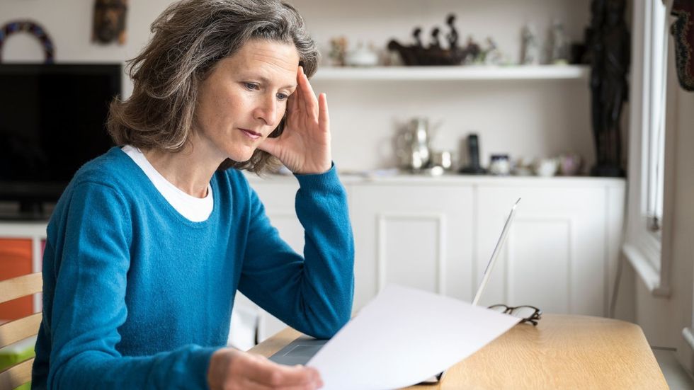 Borrower looks worried at document after mortgage rate hikes