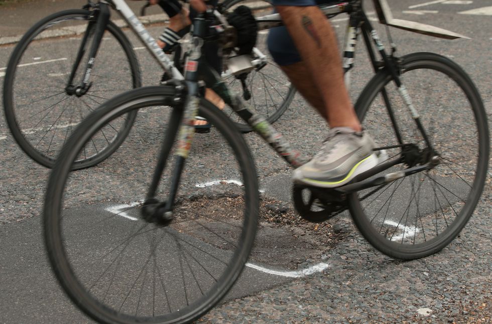 Cyclist driving over a pothole
