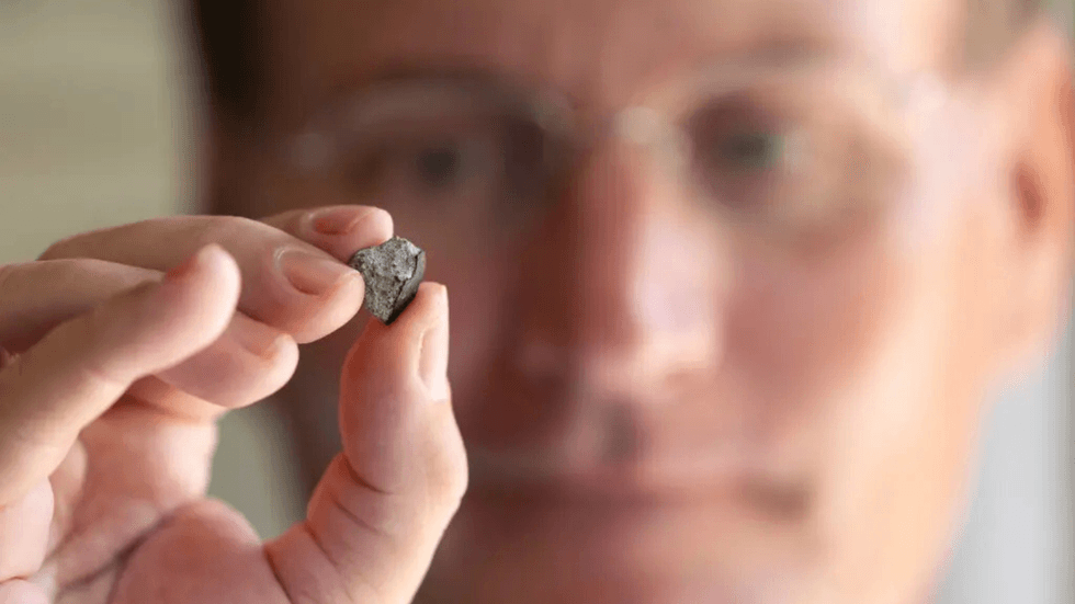 Harris holding up meteorite fragment