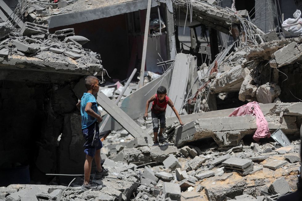 Palestinian boys inspect the site of a morning Israeli strike on a house, in Gaza City