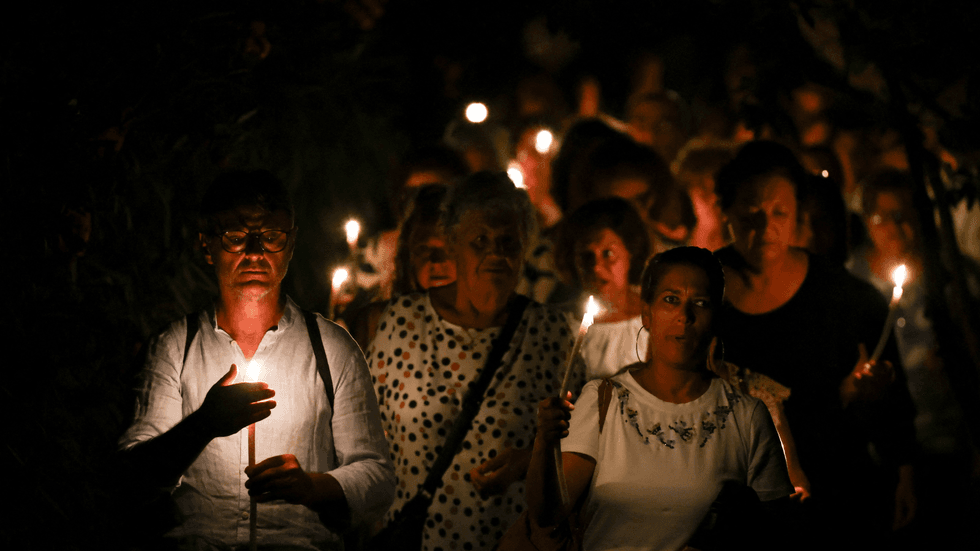 People hold candles during a vigil in solidarity with migrants