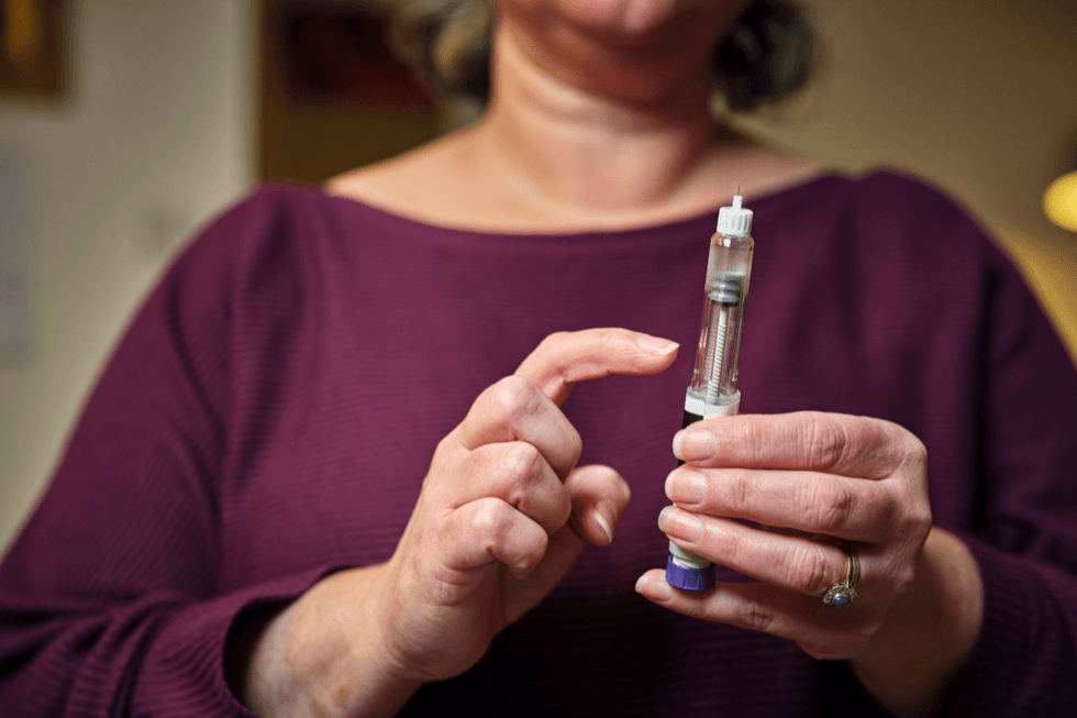 Person holding weight loss jab