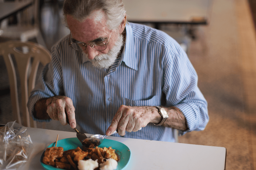 SENIOR MAN EATING MEAL