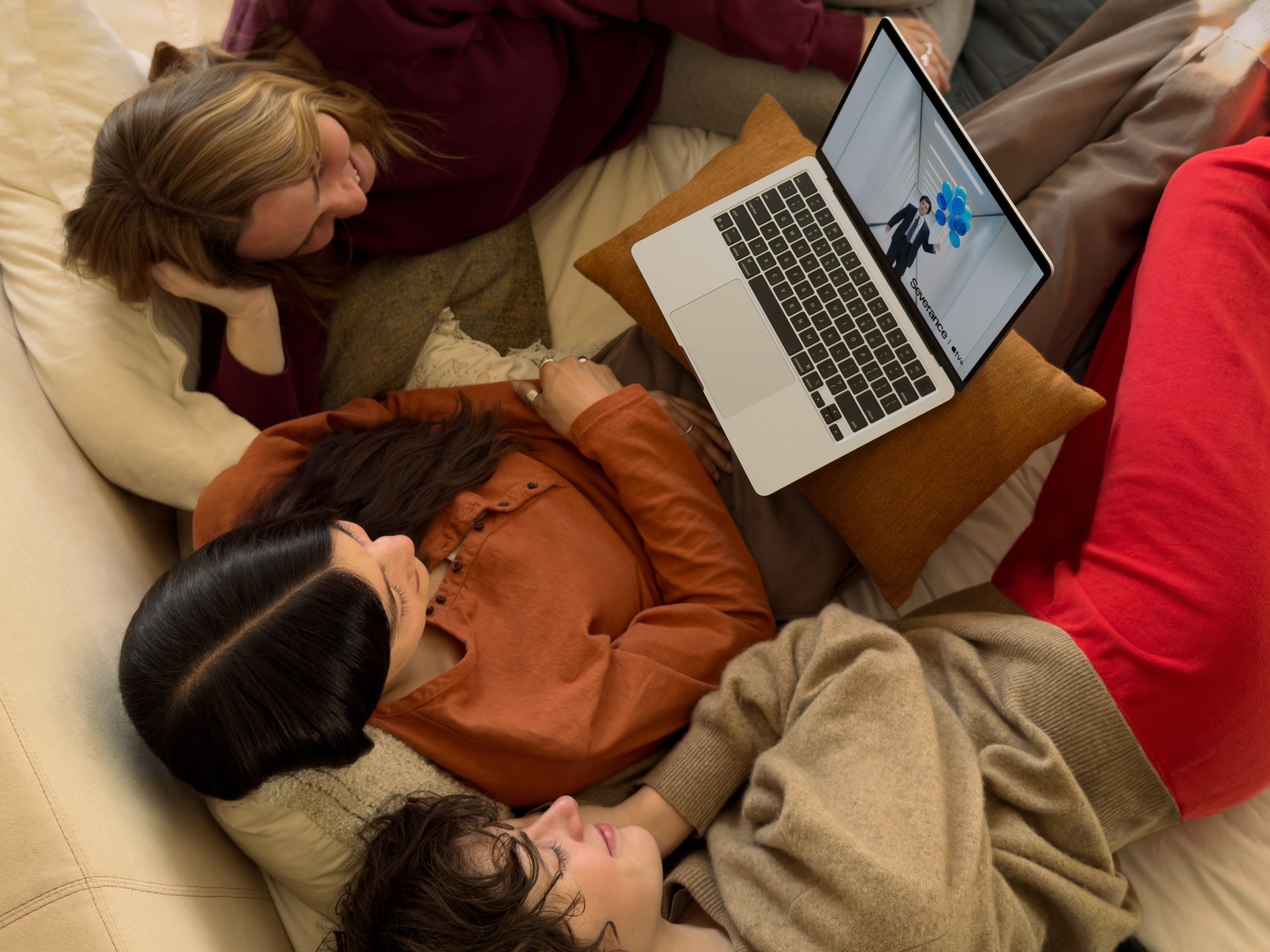 three girls on the sofa watching a show on the new macbook air