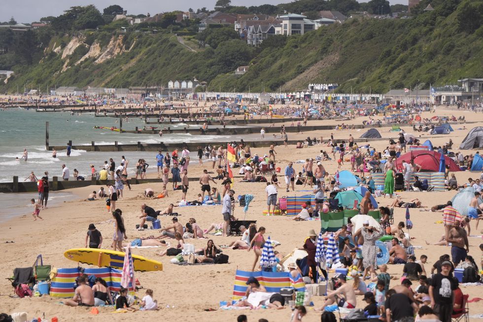 \u200bPeople enjoy the warm weather on Bournemouth Beach in Dorset.