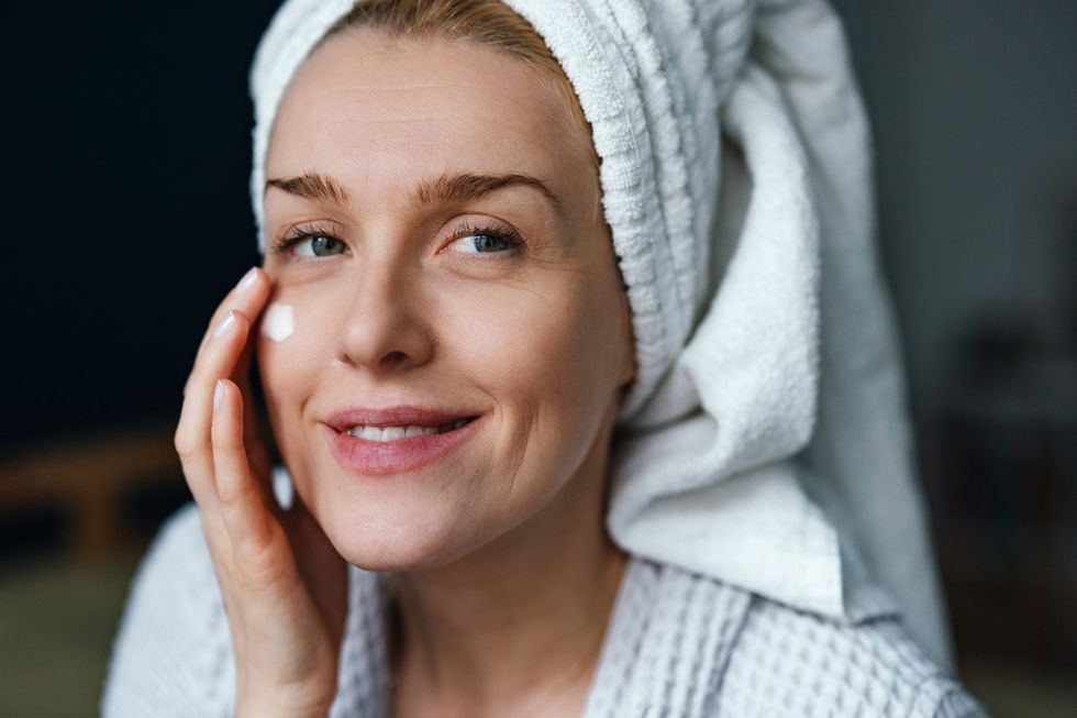 Woman applying SPF to her face