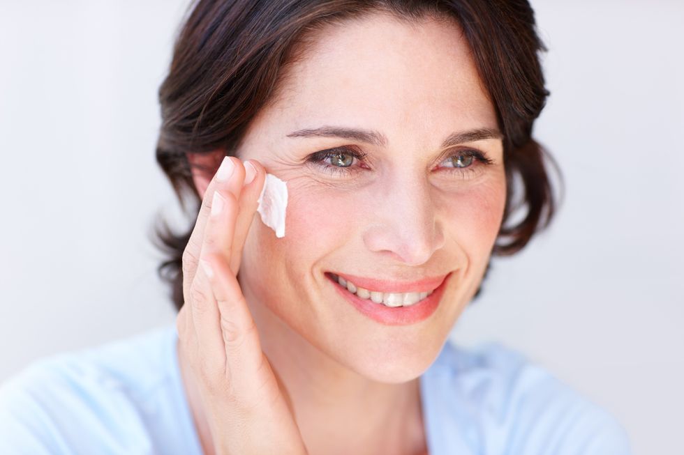 Woman applying sunscreen to her face
